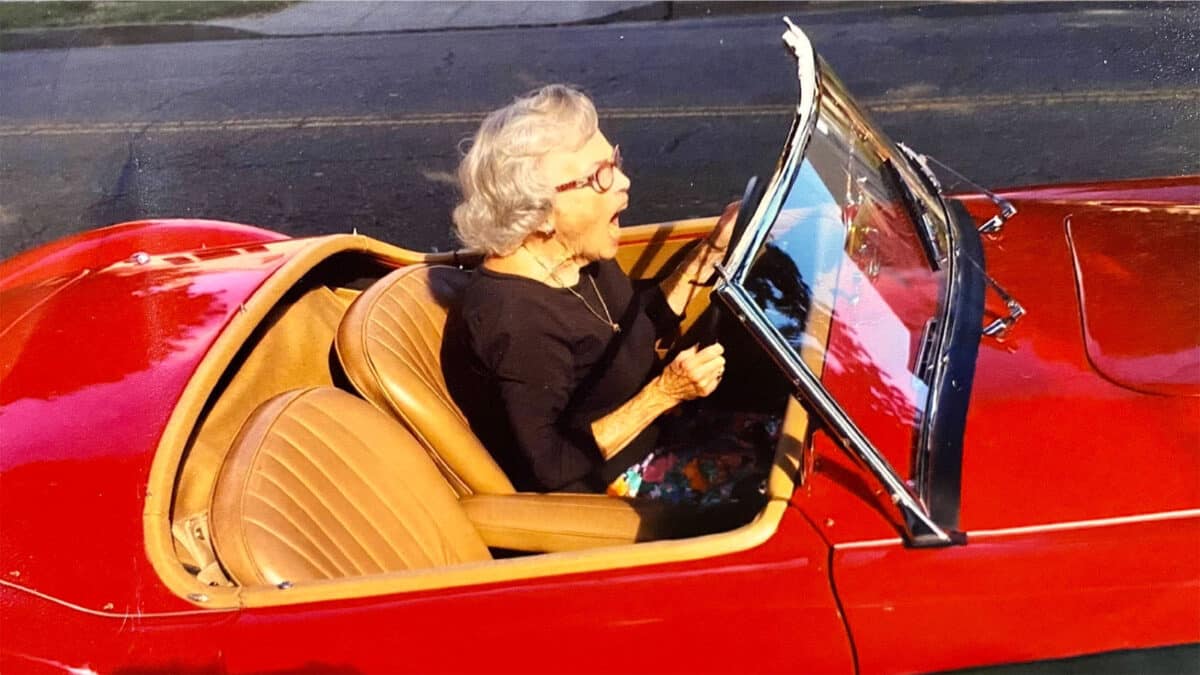 Alameda Post - Ginny Krutilek makes an excited expression while driving a bright red sports car
