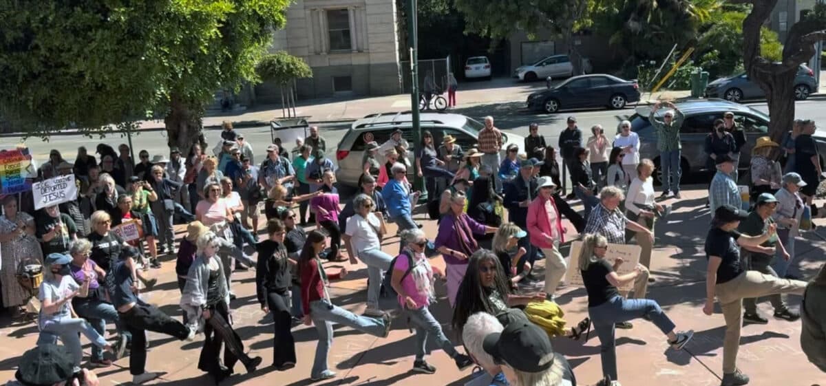 Alameda Post - Rally participants outside City Hall line dance to Bob Marley's "Get Up, Stand Up." Berkeley Poet Laureate Aya DeLeon, front center, led the moves.