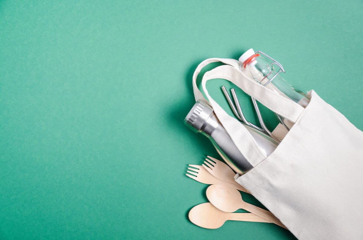 Alameda Post - a canvas bag full of zero waste products like metal straws, reusable water bottles, and bamboo utensils 
