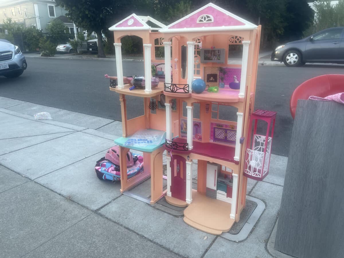 Alameda Post - a large pink plastic dollhouse sitting on the sidewalk