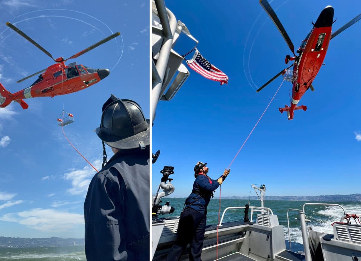 Alameda Post - an AFD firefighter stands on a boat and holds a rope connected to a red helicopter. The rope holds a metal basket.