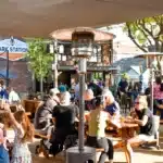 Alameda Post - lots of people sit outdoors at picnic tables at Park Station