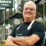 Alameda Post - Mike Stevens Stands in front of Island Savoy Market and smiles.