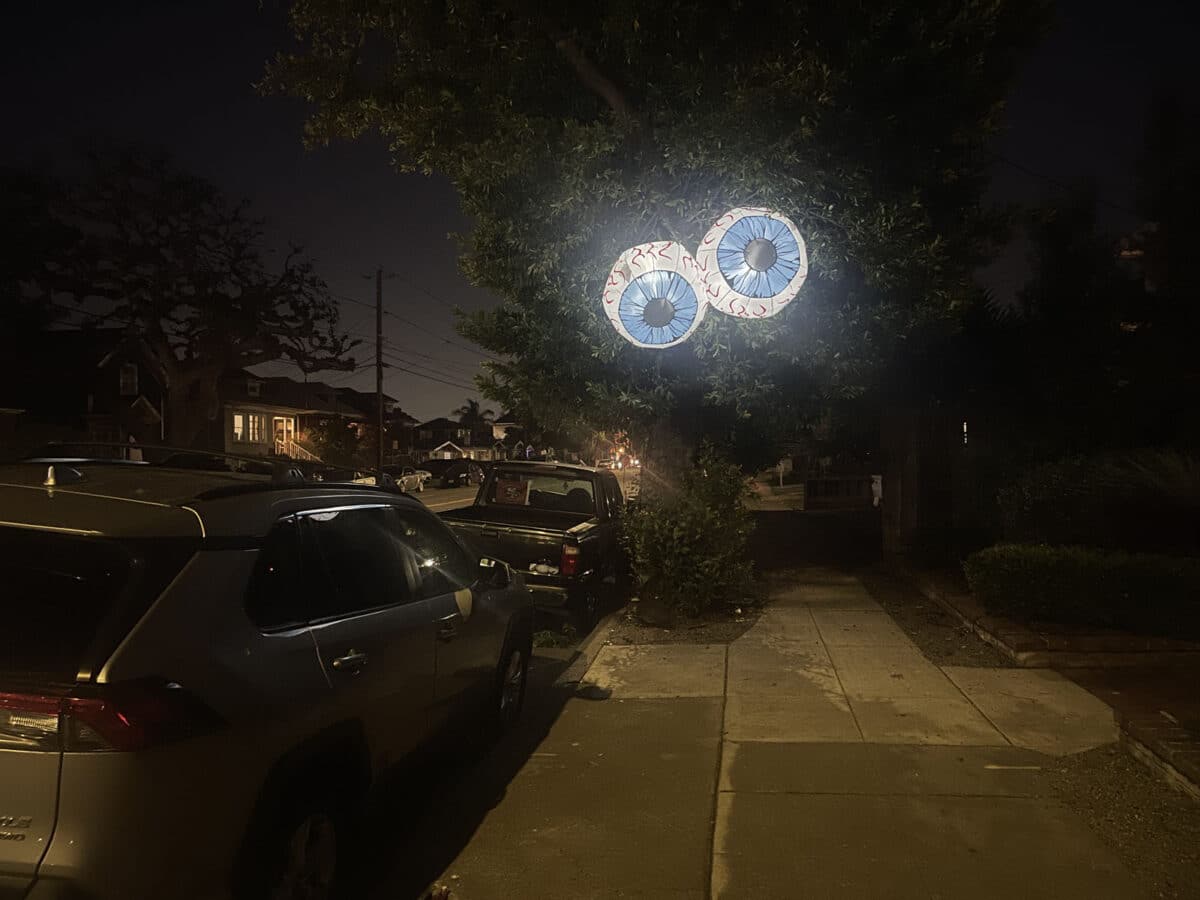 Alameda Post - Two large inflatable light up eyeballs in a tree at night.