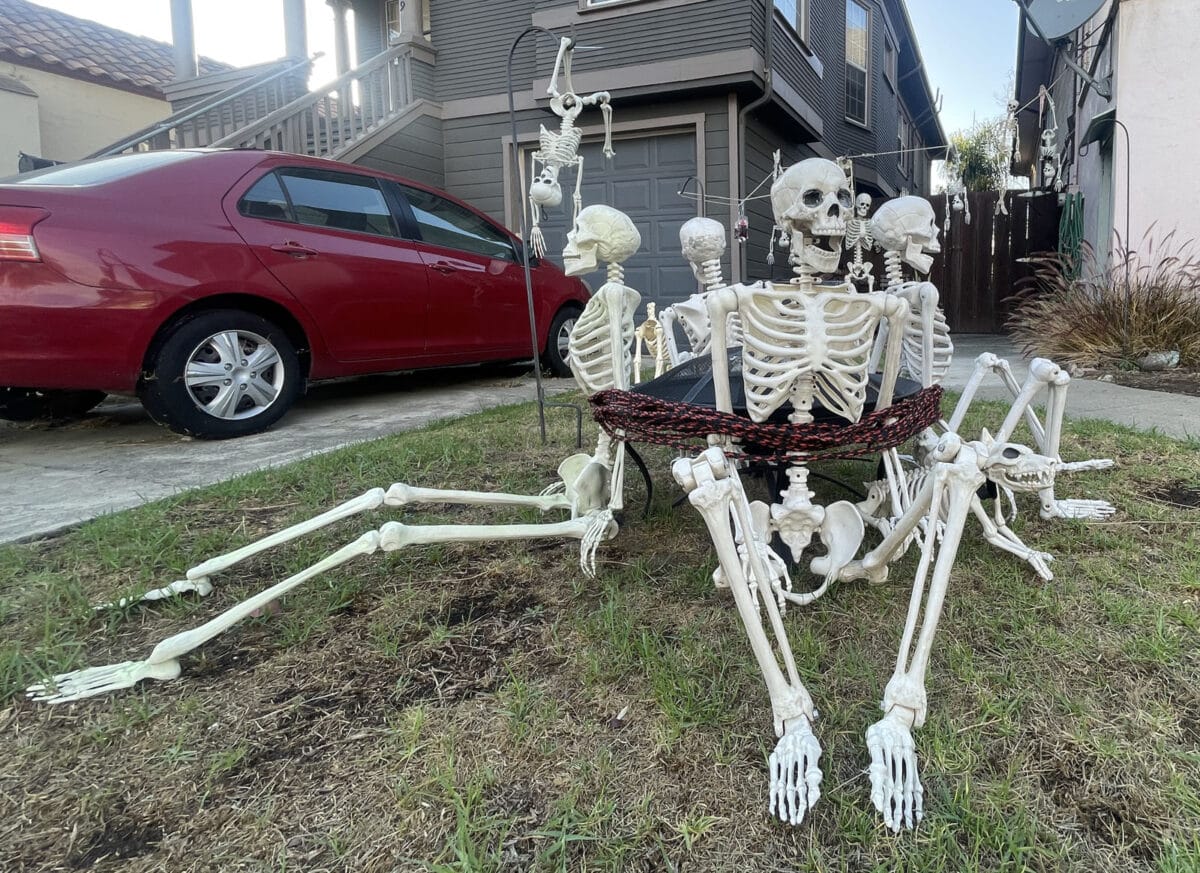 Alameda Post - Four decor skeletons in a front yard, tied together with rope like prisoners.