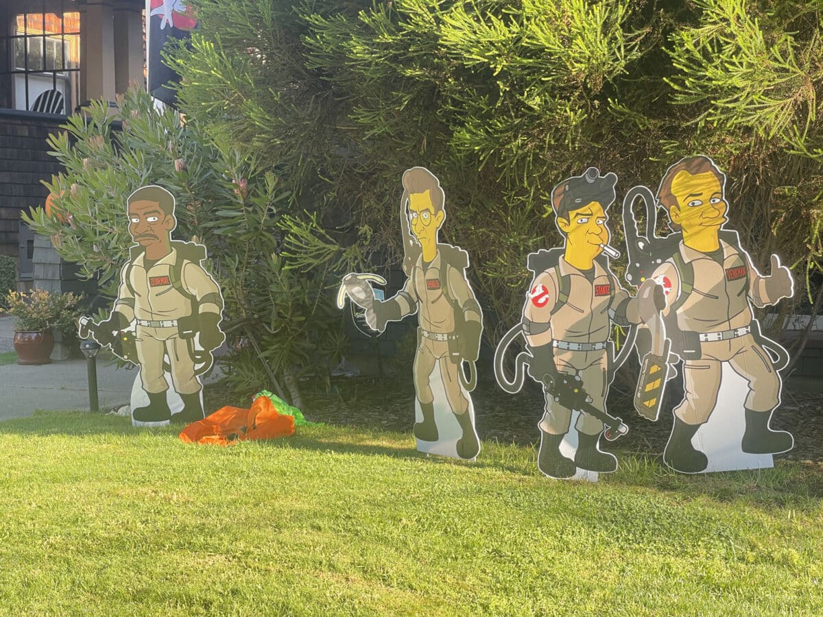 Alameda Post - Large cardboard cutouts on somebody's lawn. They are of ghostbusters, drawn in a style similar to the Simpsons. 