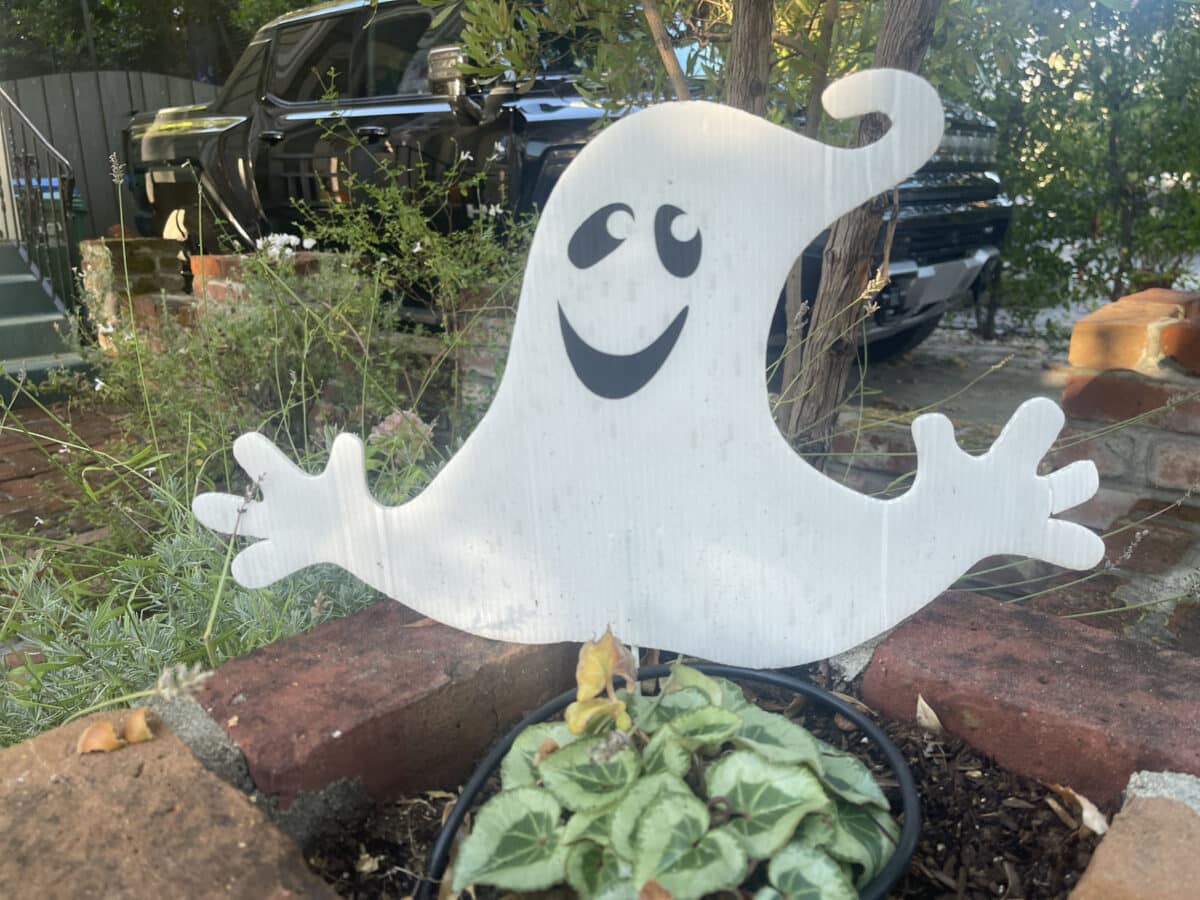 Alameda Post - A small smiling ghost sits in a planter box.