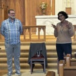 Alameda Post - A man and woman stand at the front of Christ Episcopal Church and talk.
