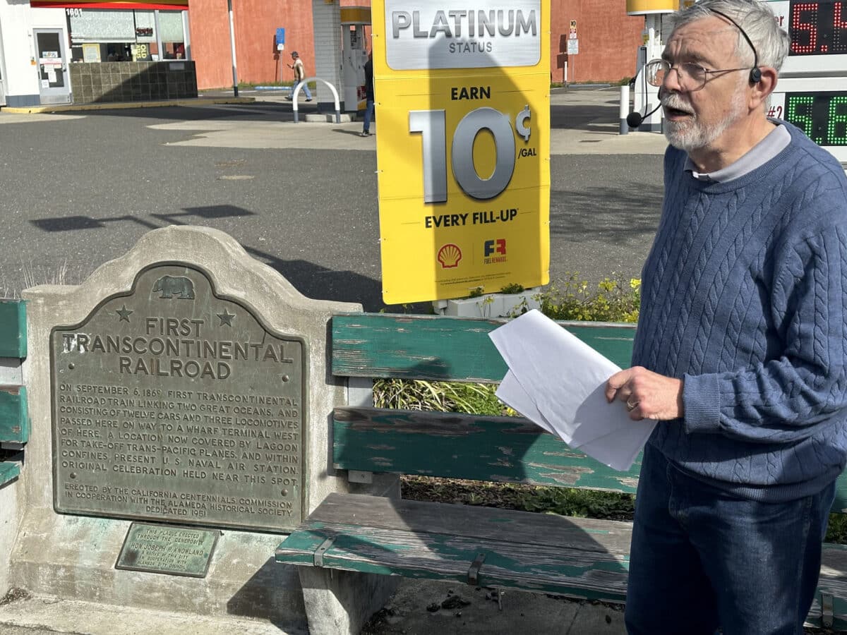 Alameda Post - A tour guide stands in front of a memorial plaque labeled "First Transcontinental Railroad"