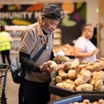 Alameda Post - An Alameda Food Bank shopper picks out potatoes.