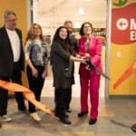 Alameda Post - Local leaders smile and hold a huge pair of scissors at the ribbon cutting of the Alameda Food Bank.