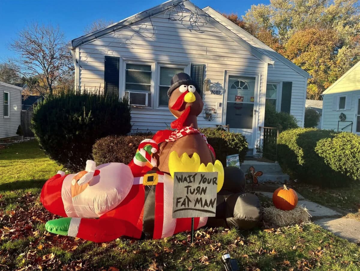 Alameda Post - An inflatable turkey standing on an inflatable Santa Claus. A sign says "Wait your turn fat man"