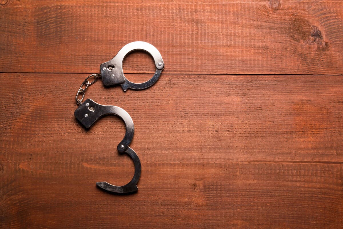 Alameda Post - A pair of open handcuffs of a table. 