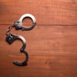 Alameda Post - A pair of open handcuffs of a table.