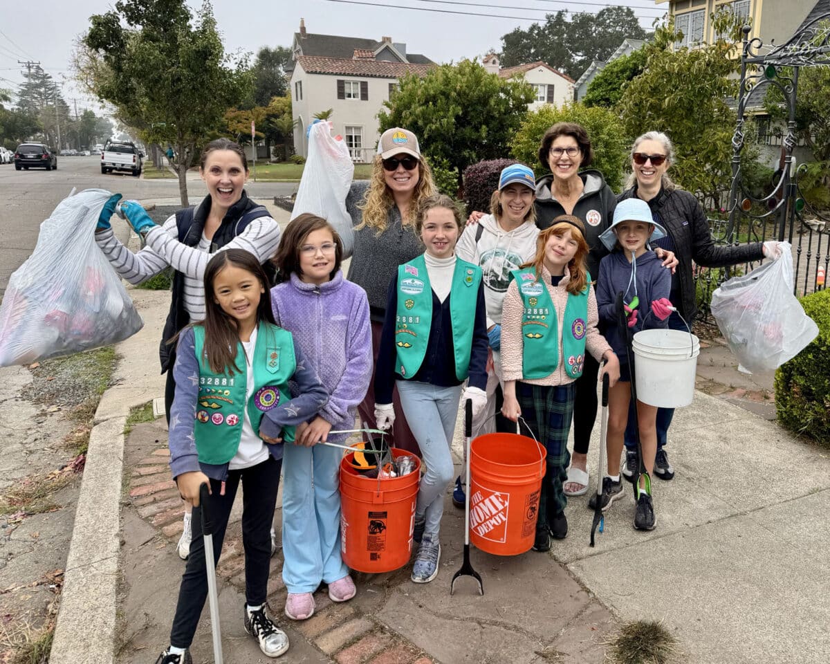 Alameda Post - Girl Scouts stand with trash collecting gear and smile. Behind them are some adults, including current Alameda mayor Ashcraft.