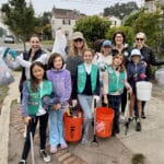 Alameda Post - Girl Scouts stand with trash collecting gear and smile. Behind them are some adults, including current Alameda mayor Ashcraft.
