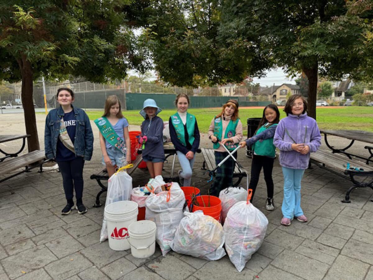 Alameda Post - Seven girl scouts proudly stand around bags of trash in Franklin Park. 