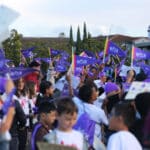 Alameda Post - A group of elementary students wave purple flags in the air.