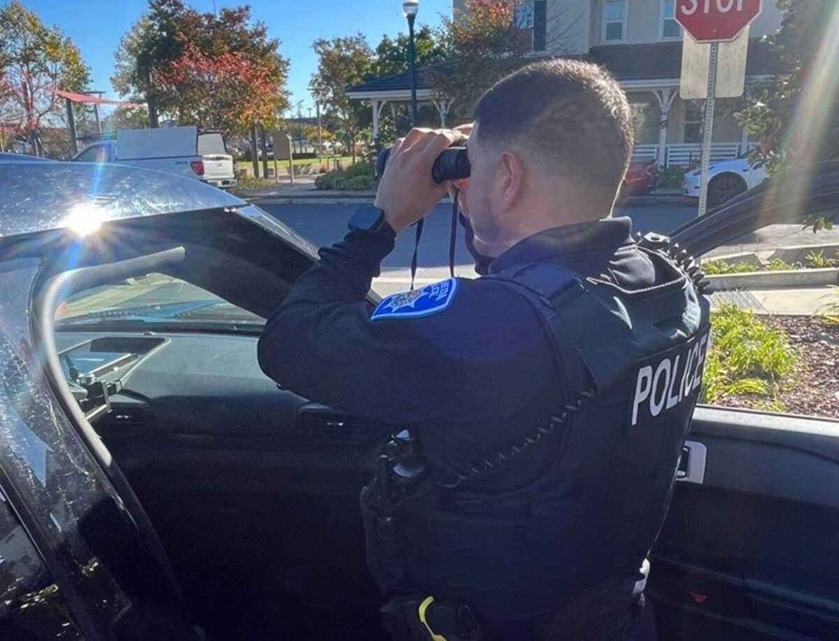 Alameda Post - An Alameda Police officer looks through a pair of binoculars. 