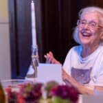 Alameda Post - An older Patricia Ferris Millosovich with white hair smiles at the dinner table.