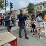 Alameda Post - A brass band marches down the Park Street sidewalk.
