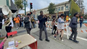 Alameda Post - A brass band marches down the Park Street sidewalk.