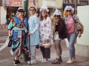 Alameda Post - Five women dressed up in Grandma outfits for GrannyCon stand at the corner of Park and Central.