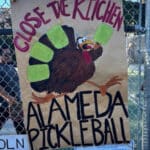 Alameda Post - A hand painted sign with a turkey on it that says "Close the Kitchen. Alameda Pickleball." The sign is on the Lincoln Pickleball court.