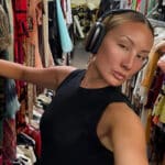 Alameda post - Miyako Bellizi takes a selfie while looking through clothing racks.