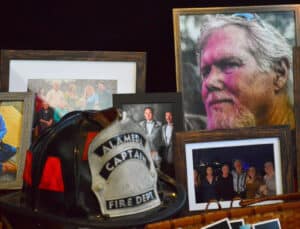 Alameda Post - A memorial display with photographs and an Alameda Captain of the Fire Department helmet.
