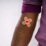 Alameda Post - An arm with a bandaid and a heart.