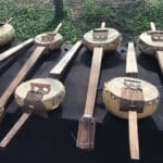 Alameda Post - Eight banjos laid out on a table.