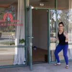 Alameda Post - A woman stands outside the door to Island Inferno and holds a thumbs up.