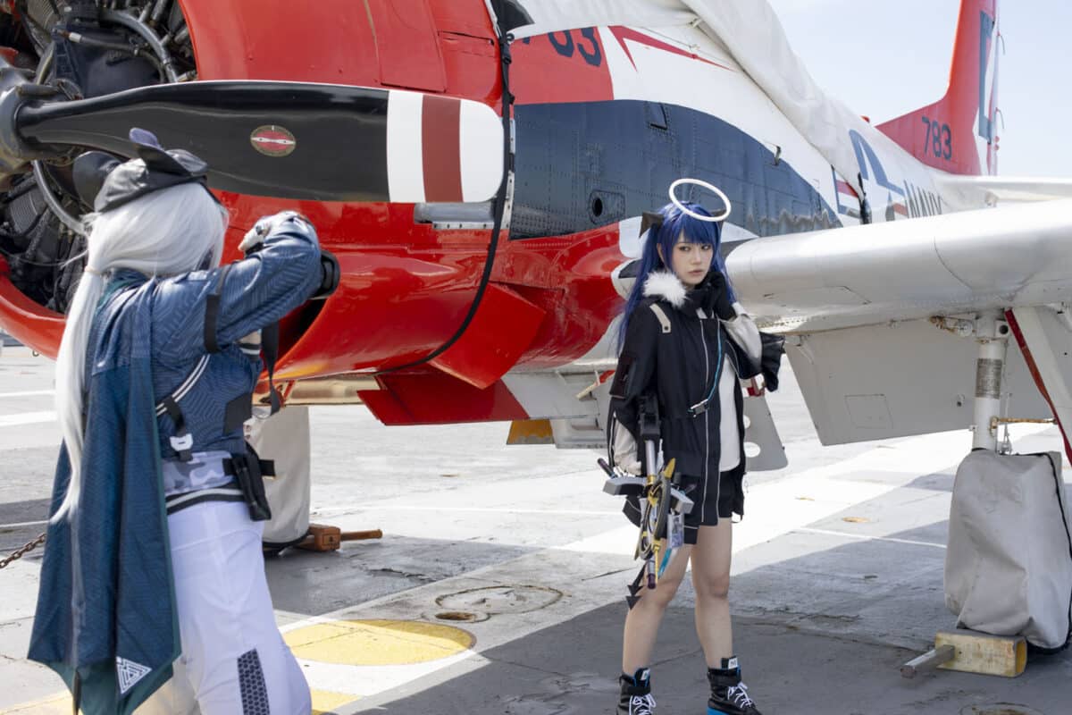 Alameda Post - A cosplayer poses in front of a Jet while another snaps a photo.