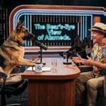 Alameda Post - A generated image of a German shepherd interviewing a man in a Hawaiian shirt.