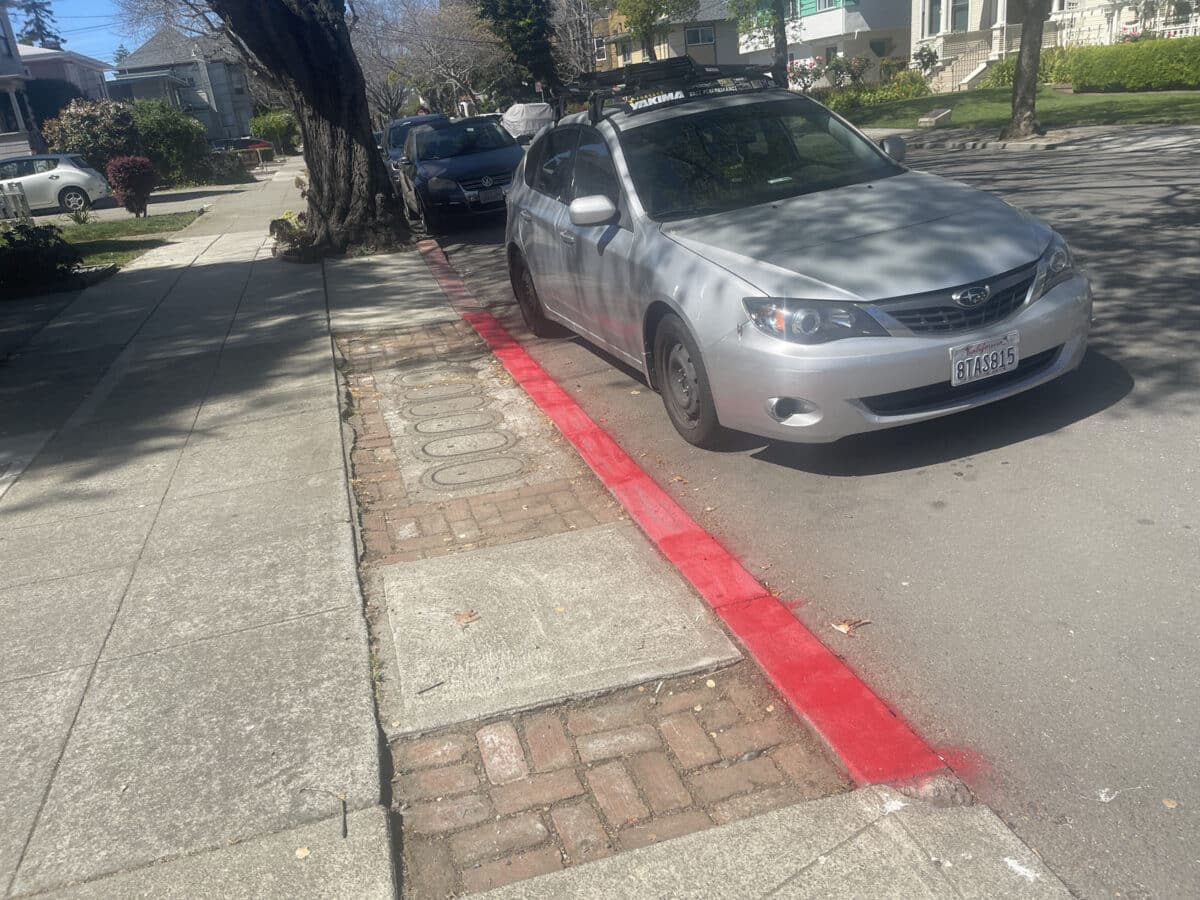 Alameda Post - A red curb that looks to have been recently and poorly painted.
