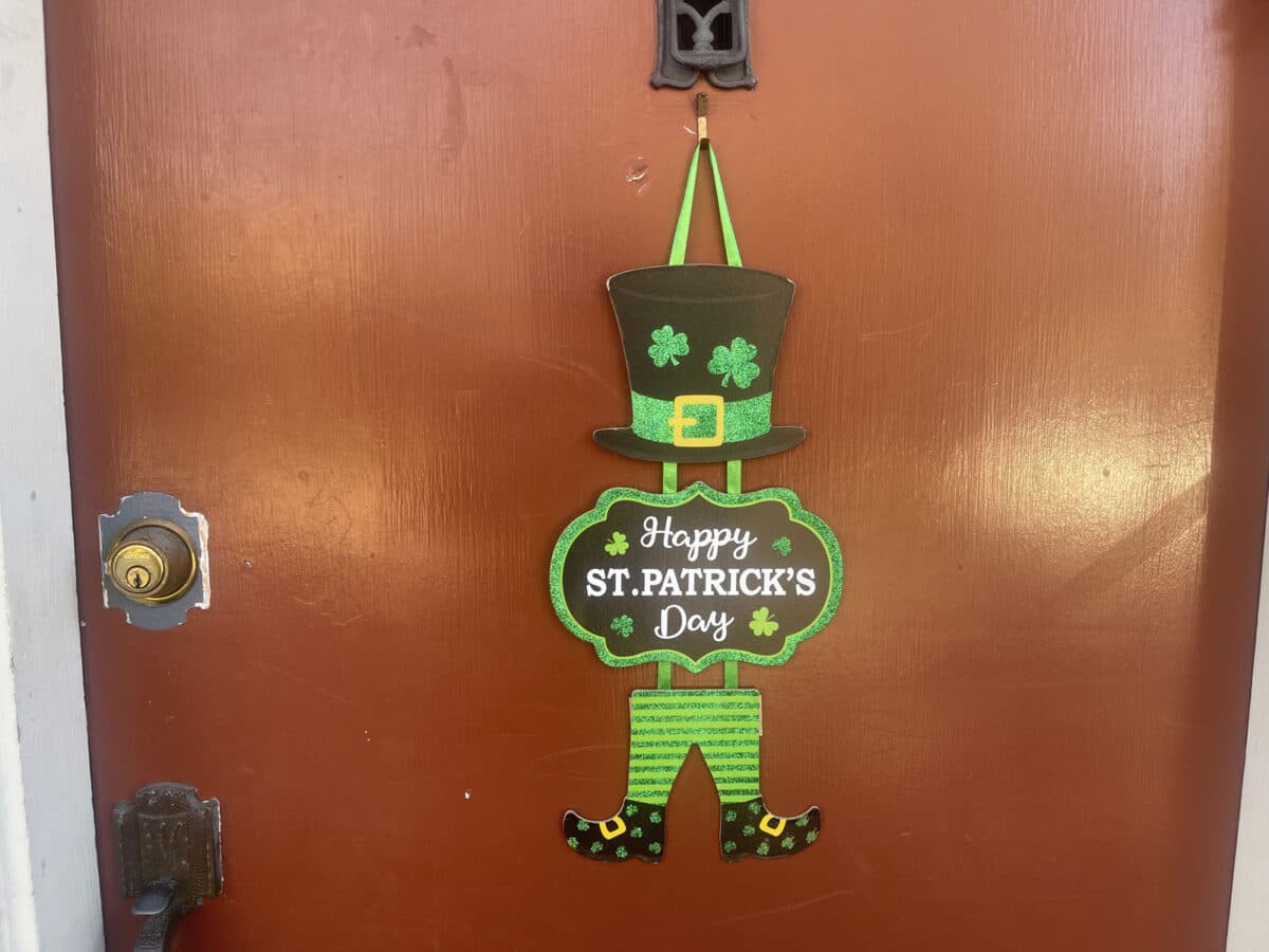 Alameda Post - A door hanger of leprechaun clothes that says "Happy St. Patrick's Day."