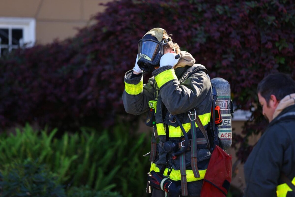 A firefighter puts on protective gear. 