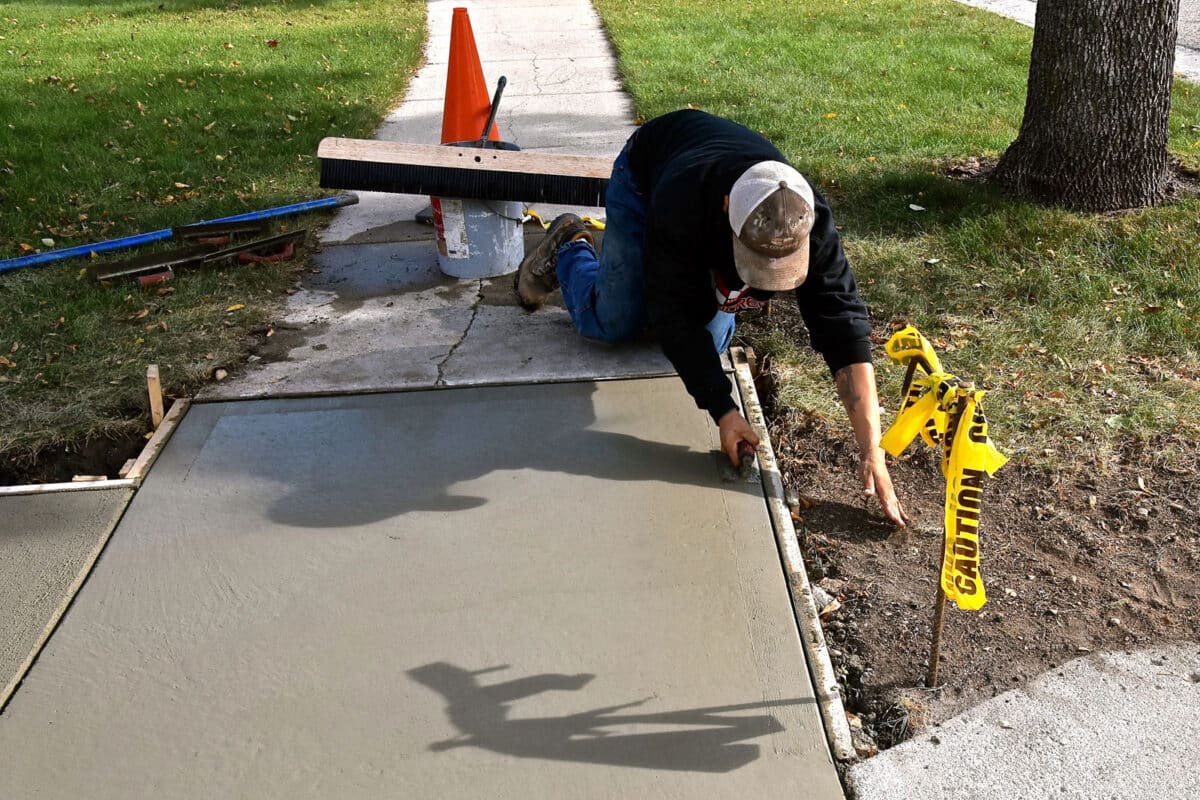 Alameda Post - A worker repairs a sidewalk.