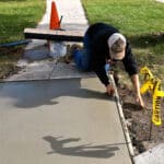 Alameda Post - A worker repairs a sidewalk.