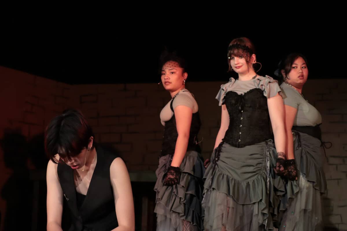 Alameda Post - Three actresses as the fates and another actress in a vest kneeling on the ground.