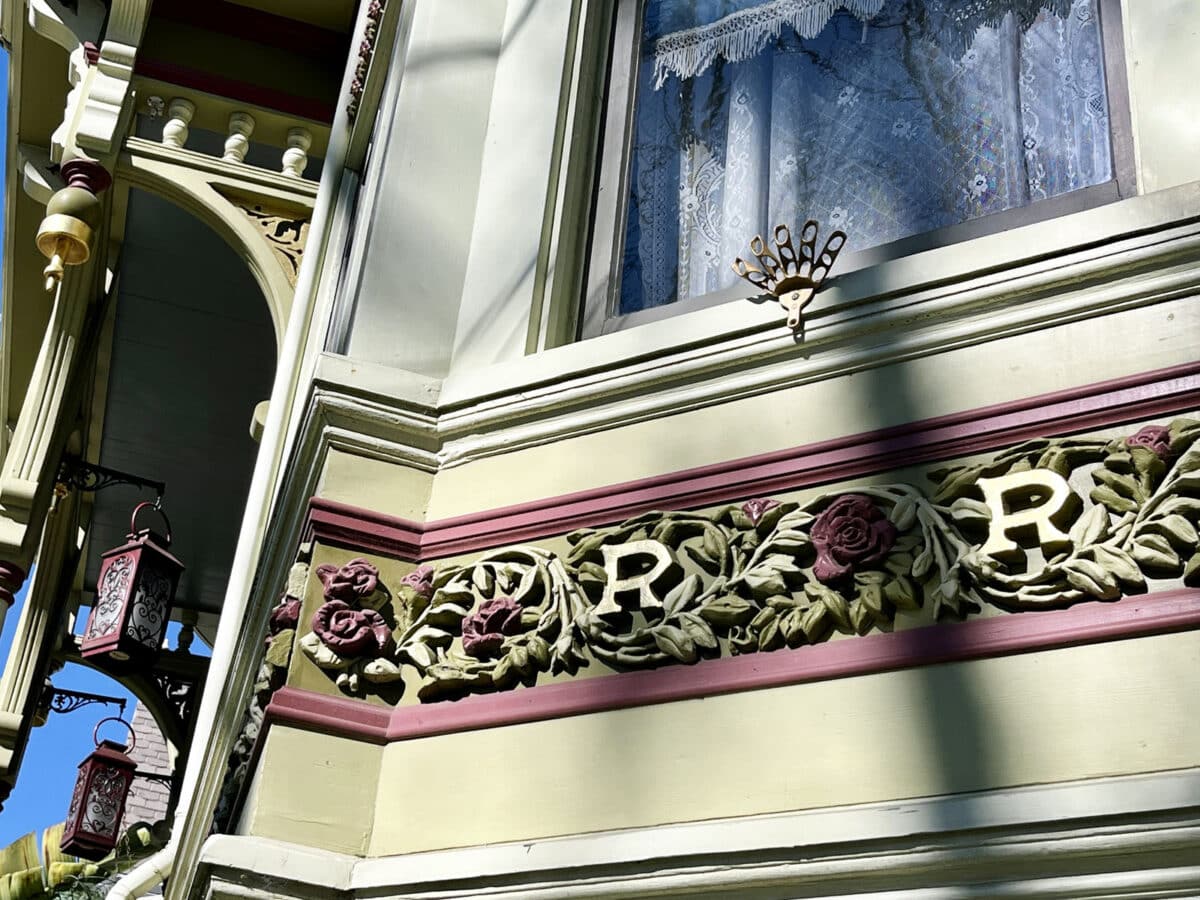 Alameda Post - An ornate plaster cast on the outside of a home with vines, roses, and the letter R.