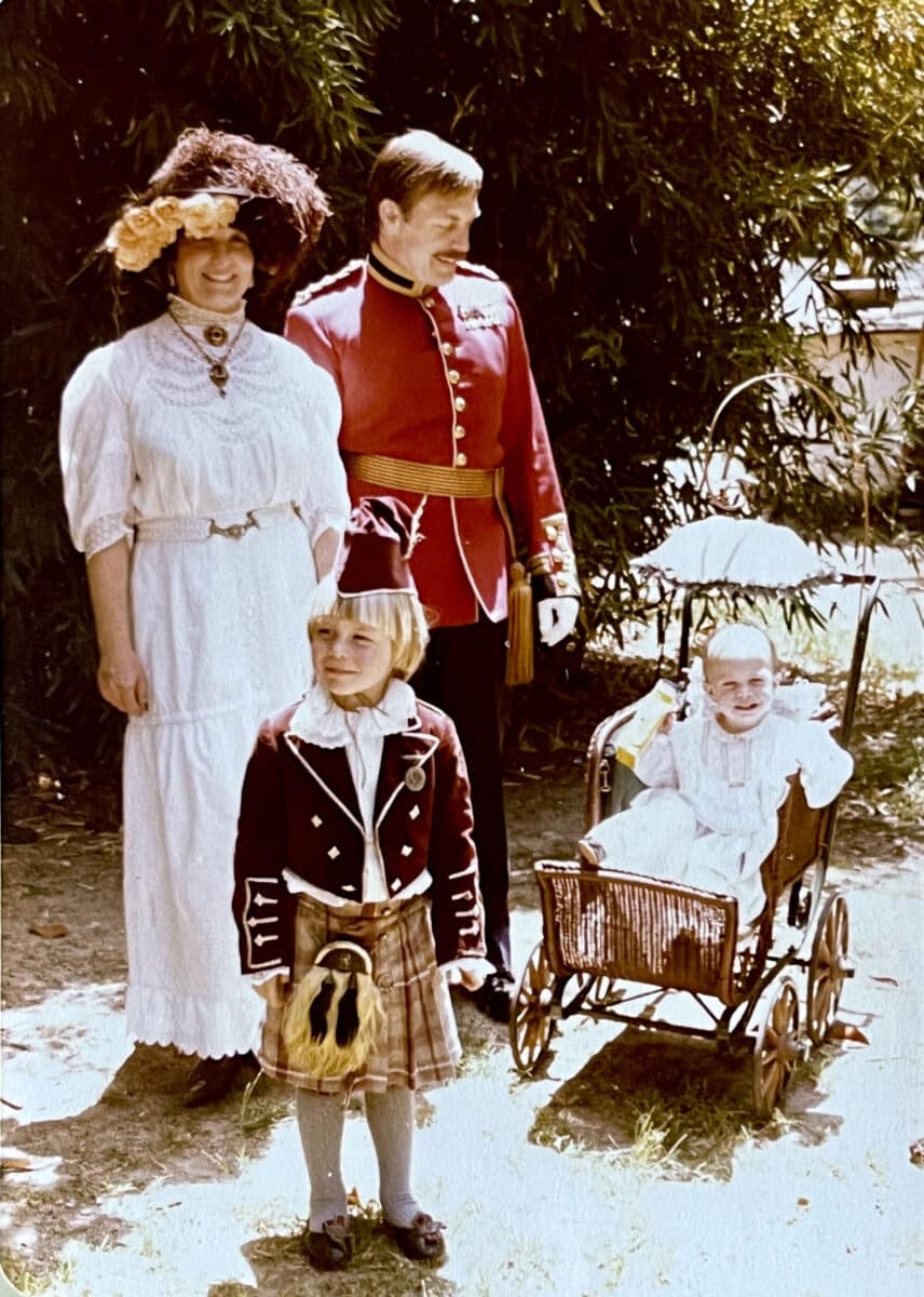Alameda Post - A family of four dressed in period attire stand and smile. One child is young enough to be in a stroller, and the other stands in a small military uniform.