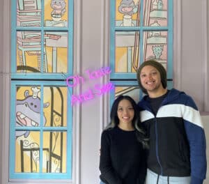 Alameda Post - a smiling couple inside a backdrop at Doodlecakes.