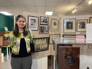 Alameda Post - A woman stands in front of a display for Women's History Month at the Alameda Museum.
