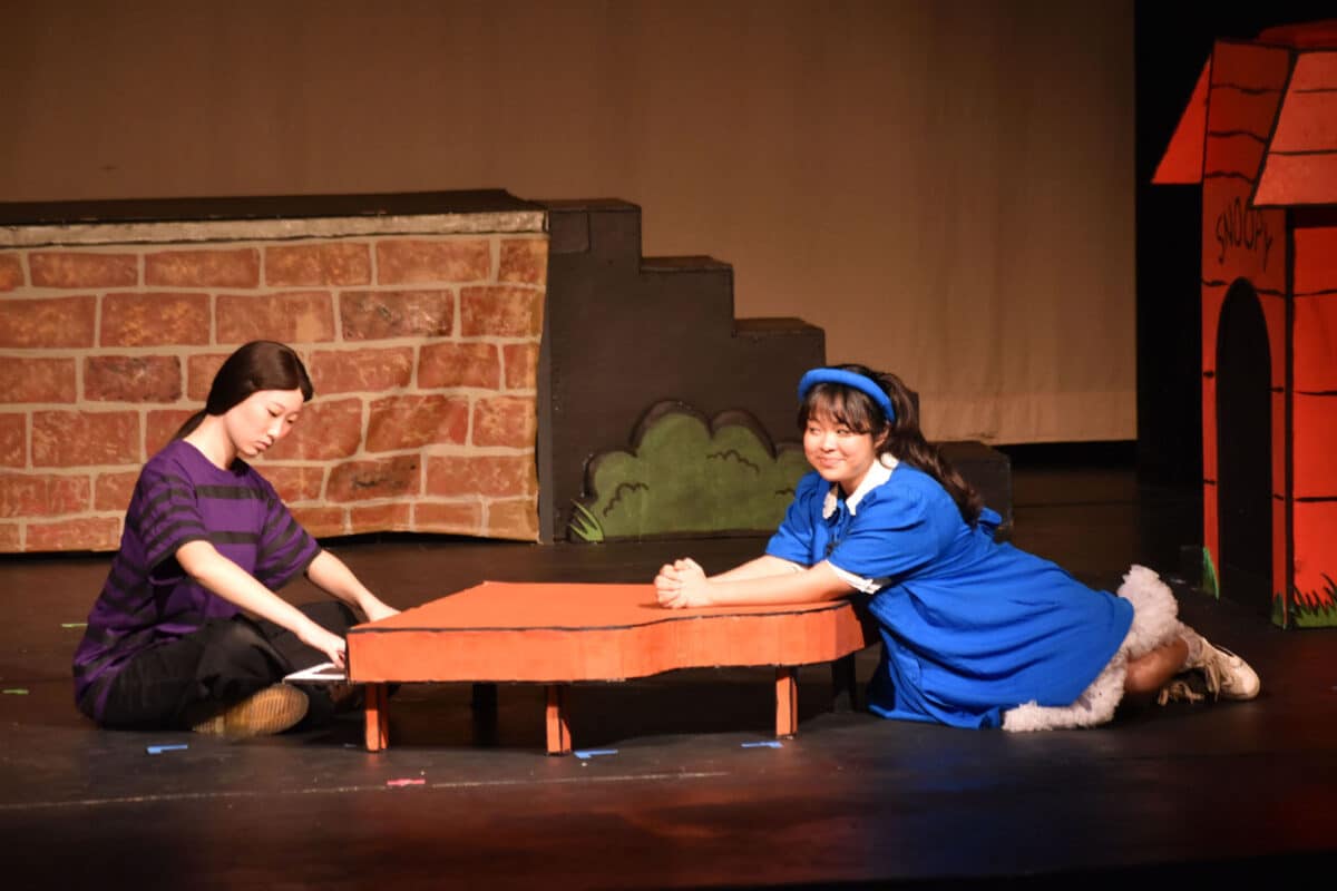 Alameda Post - Two characters in You're a Good Man Charlie brown. Schroeder plays while Lucy listens. 