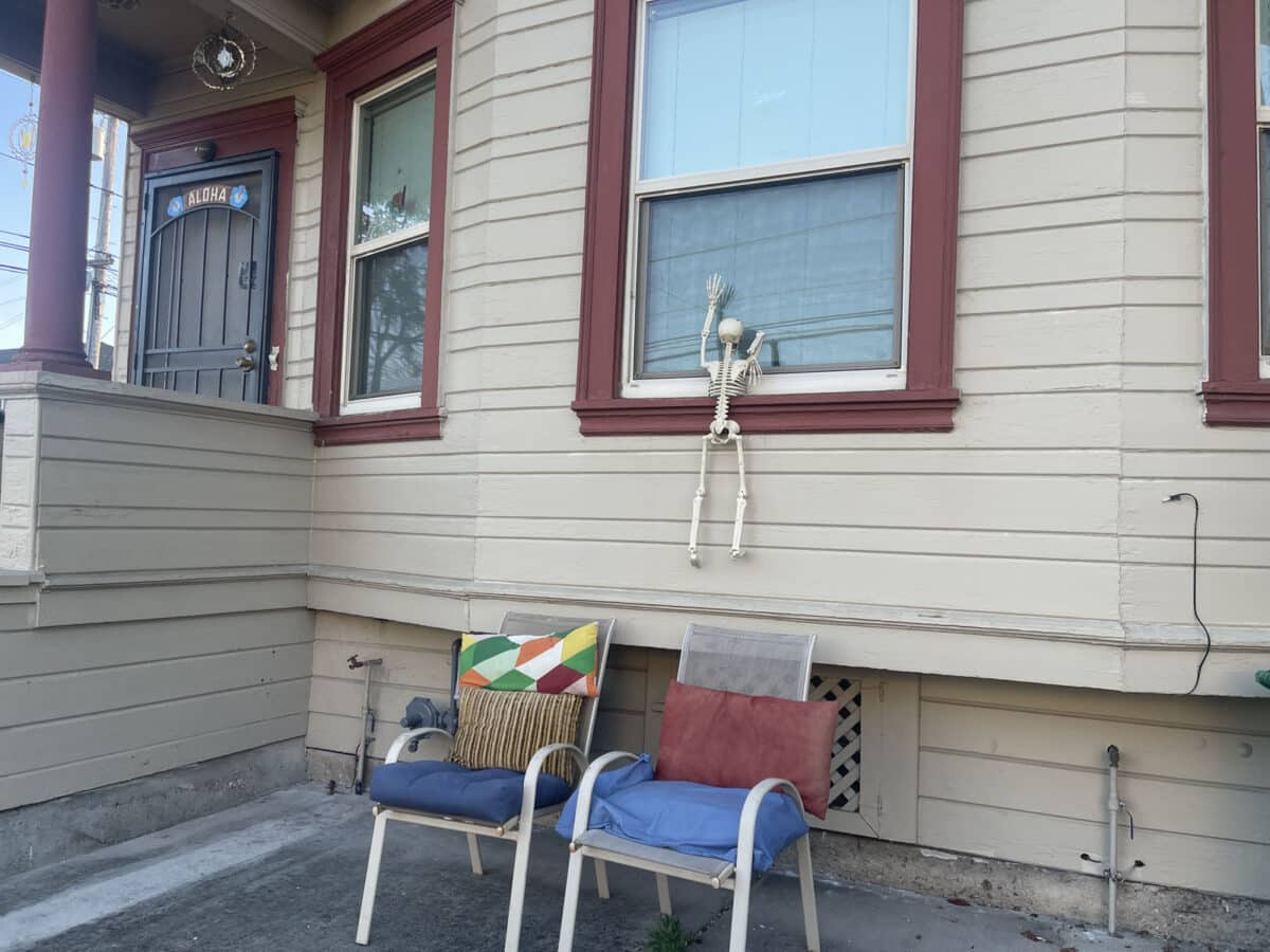 Alameda Post - A skeleton decoration that appears to be trying to climb into a window.