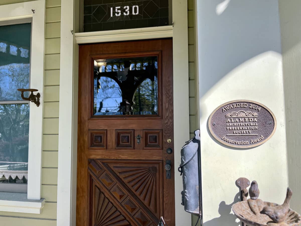 Alameda Post - An ornate front door and entryway of a home, and a plaque from the architectural preservation society. 