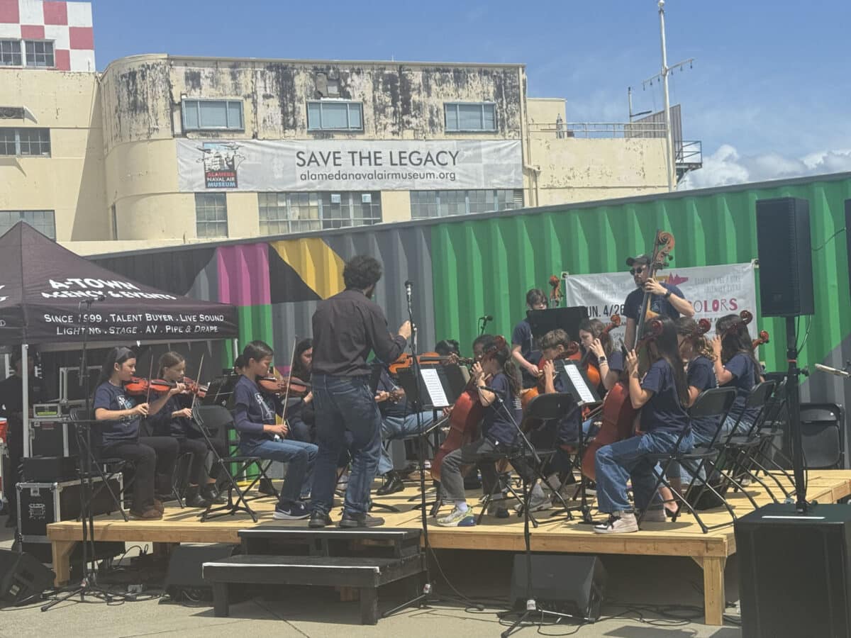 Alameda Post - A director directs a full band on risers. 
