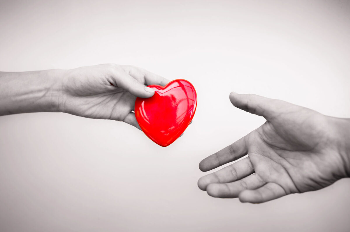 Alameda Post - A hand hands another outstretched hand a cartoon red heart.
